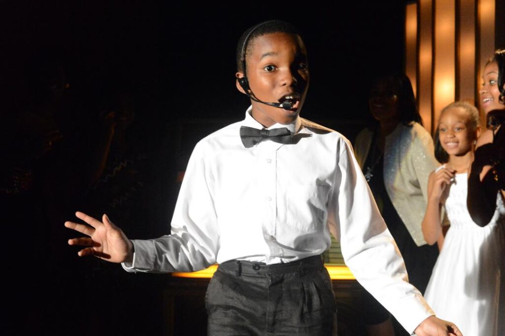Boy in bow tie singing with headset