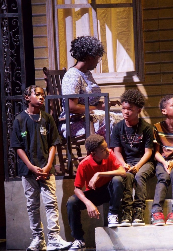 Young actors on the steps with a neighbor in a rocking chair behind them